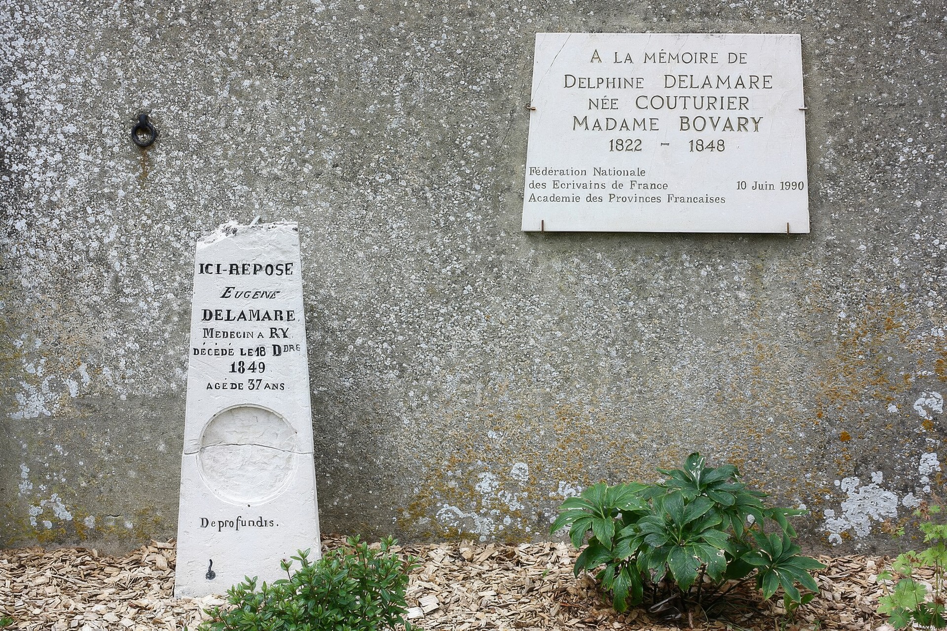 Могильный комплекс супружеской пары Деламар на кладбище в деревне Ри недалеко от Руана, Франция. На фотографии видно, что на памятной доске под настоящим именем Дельфины выгравировано второе имя, а именно — Мадам Бовари.