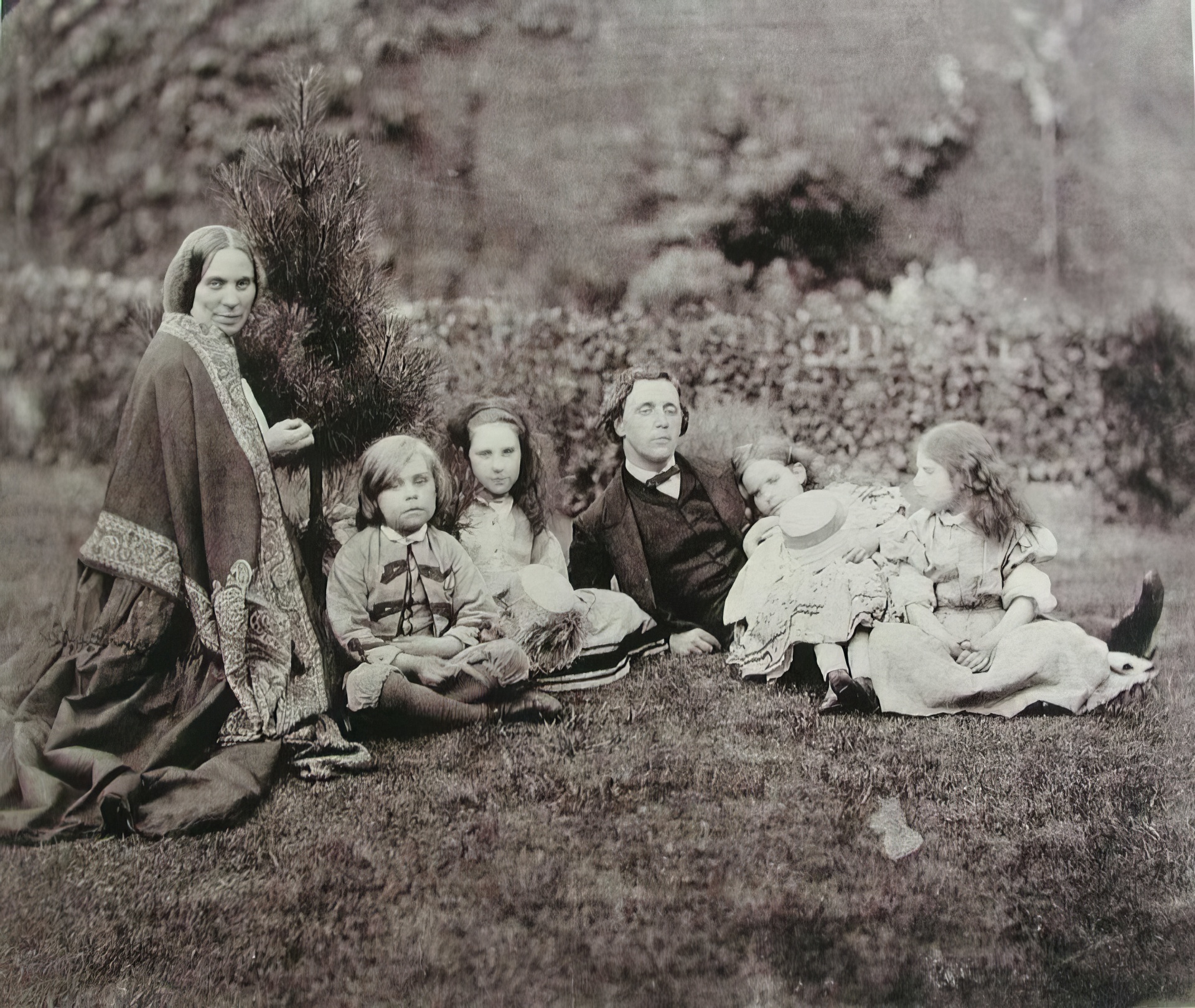 Английский математик, писатель и фотограф Чарльз Лютвидж Доджсон, более известный как Льюис Кэрролл (1832–1898), с миссис Джордж Макдональд и четырьмя детьми, отдыхающими в саду.