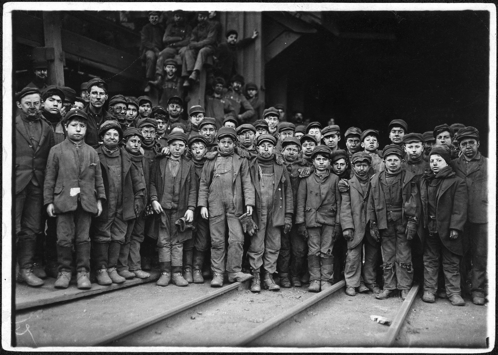 Группа учеников трубочистов. Все эти мальчики, вероятно, работали на главного трубочиста в левом верхнем углу. Он тоже очень низкорослый, что указывает на то, что в детстве он тоже был учеником.
Льюис Хайн; Общественное достояние.